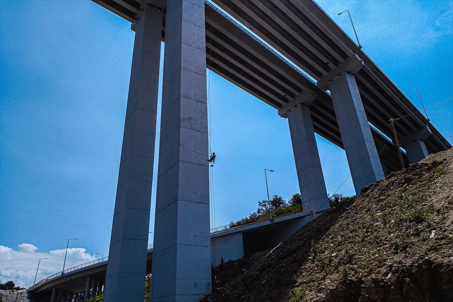 Alipinisti farbaju visoki most